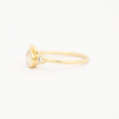 This ring captures a graceful, rolling wave in solid gold to curl around a bezel-set diamond. Accentuated by another, smaller diamond to the side, this center diamond within its golden frame. The low-profile design welcomes an active lifestyle, without compromising size or impact. This alternative engagement style can be worn with the matching band for a perfect pairing to treasure forever. Made in the U.S.A. 14 karat gold with 0.25-0.3ct Modern Brilliant Cut White Diamond (recycled, VS clarity, Luxury Bezel Set Birthstone Ring For Anniversary, Luxury Birthstone Ring With Bezel Setting For Anniversary, Elegant Signet Ring With Smooth Bezel For Anniversary, Luxury Rings With Smooth Bezel For Anniversary, 14k Gold Bezel Setting Halo Ring For Anniversary, Luxury Birthstone Bezel Setting Promise Ring, Classic Cluster Ring With Bezel Setting For Anniversary, Elegant Wedding Signet Ring With Smooth Bezel, Elegant Anniversary Signet Ring With Smooth Bezel