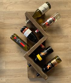 several bottles of wine are sitting in a wooden holder on the floor next to each other