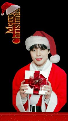 a boy in a santa hat holding a gift box with the words merry christmas written on it