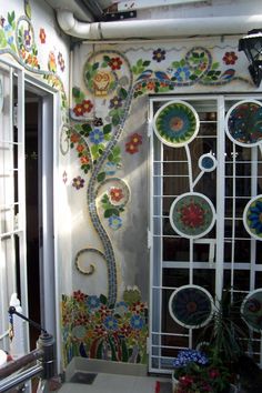 the bathroom is decorated with colorful flowers and decorative glass panels on the wall, along with a toilet