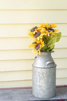 sunflowers in an old metal milk can on a porch