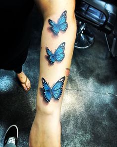 three blue butterflies on the right leg and one in the middle with black dots around it