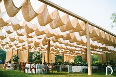 an outdoor tent with tables and chairs under it