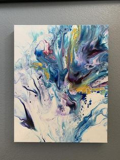 an abstract painting with blue, yellow and white colors on a gray wall in a black frame