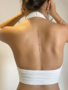 the back of a woman's body with tattoos on her upper and lower back