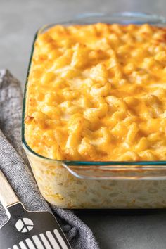 a casserole dish with macaroni and cheese in it next to a spatula