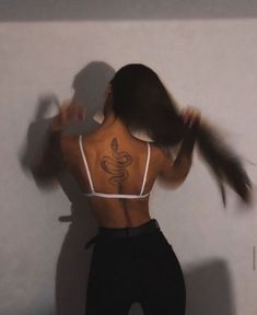 the back of a woman's body with tattoos on her upper and lower half