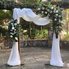 an outdoor wedding setup with white flowers and greenery