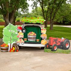 an outdoor display with a tractor, apples and cupcakes on the back of it