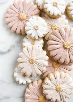 cookies decorated with pink and white flowers on a marble surface