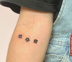 small four leaf clover tattoo on the left inner arm and lower arm, in black ink