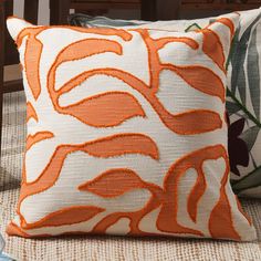 an orange and white pillow sitting on top of a chair