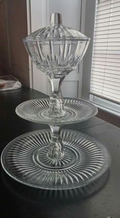 two clear glass dishes sitting on top of a black table next to a white door