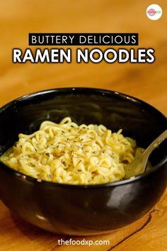 a black bowl filled with noodles on top of a wooden table