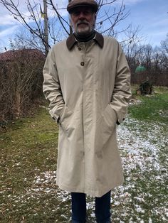 "Vintage 90s trench coat. Beige men's BUGATTI rain coat. Partly lined. Brown leather collar. Front hidden buttoned  coat with three hidden side pockets and one inside pocket. Breuninger tag. To fit size L  From shoulder to shoulder 25\" 63cm Chest 54\" 137cm Sleeve length 25\" 64cm Length 46,5\" 118cm In good condition, no holes or spots. Ready to wear." Classic Outerwear For Rainy Weather, Classic Outerwear For Rainy Season, Classic Long Winter Raincoat, Classic Business Raincoat For Winter, Classic Winter Business Raincoat, Classic Winter Weatherproof Raincoat, Classic Long Single Breasted Raincoat, Classic Winter Raincoat For Outdoor, Classic Weatherproof Winter Raincoat