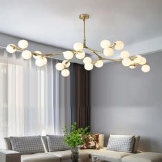 a living room filled with furniture and a chandelier hanging over the top of it