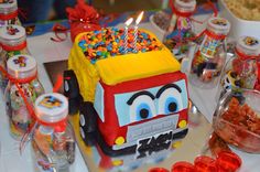 a birthday cake that looks like a truck with candles in it and candy on the side