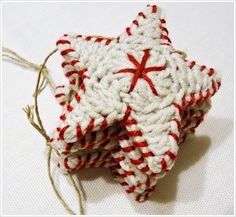 a crocheted star ornament with red and white stripes on it's side