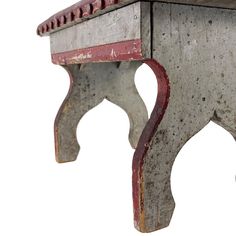 an old wooden bench with red and white paint on the top, against a white background