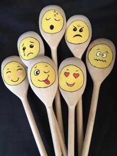 six wooden spoons with painted faces on them