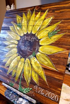 a painted wooden sign with a sunflower on it