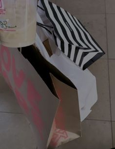 an open shopping bag sitting on top of a tiled floor next to a bottle of milk