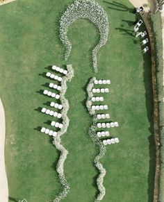 an aerial view of white chairs arranged in the shape of a spiral on green grass