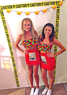 two women standing next to each other in front of a sign that says gumball machines