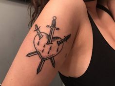 a woman with a tattoo on her arm holding a knife and a heart shaped object