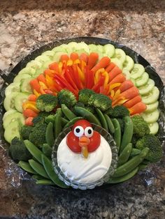 a turkey made out of veggies and carrots on a platter for thanksgiving