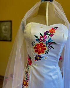 a white wedding dress with colorful flowers on it