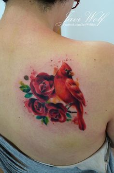 a woman with a red bird and roses tattoo on her back