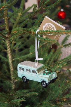 an ornament hanging from the top of a christmas tree with a vw bus on it