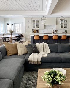 a living room filled with furniture next to a kitchen