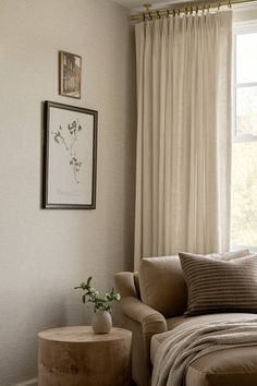 a living room with a couch, chair and table in front of a large window