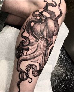 an octopus tattoo on the arm with black ink and white ink, it looks like he is