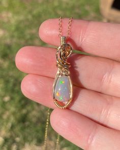 This gorgeous Ethiopian Opal pendant is hand wrapped using elegant 14k yellow gold fill wire. It is a dark base opal with stunning colors consisting of all the colors of the rainbow with a gorgeous play of color. The opal weighs 4.2 carats before wrapped. This pendant measures just a hair under 1.5 inches tall from the bottom of pendant to the top of the bail. A 14k gold fill chain is available upon purchase (as seen in photos). Chain is removable and interchangeable. I did my best to provide mu Elegant Opal Necklace With Wire Wrapped Detail, Yellow Gold Wire Wrapped Jewelry For Healing, Teardrop Ethiopian Opal Jewelry Gift, Unique 14k Gold Wire Wrapped Jewelry, Hand Wrapped Yellow Gold Jewelry As Gift, Spiritual Wire Wrapped Opal Jewelry, Spiritual Wire-wrapped Opal Jewelry, Hand Wrapped Yellow Gold Jewelry Gift, Hand-wrapped Yellow Gold Jewelry Gift