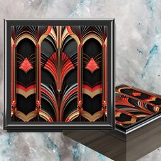 an art deco print with red and black accents on a marble background, next to a wooden box