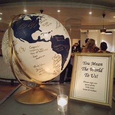 a globe with writing on it next to a sign that says you mean the world to us