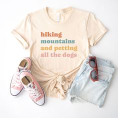 hiking mountains and petting all the dogs shirt, hiking tshirt, funny hiking shirt, hiking gift, hiking tee, gift for hiker UNISEX T-SHIRTS Short sleeve Unisex T-shirt - 100% combed and ring-spun cotton (fiber content may vary for different colors) - Light fabric - Tear away label - Runs true to size SIZING AND COLORS - Please refer to size chart on the listing photos in every listing for a detailed sizing chart with measurements. - We use soft and fitted unisex T-shirts from Bella Canvas that are in standard men's sizes.  - Women will typically need to order one size down SHIPPING AND PRODUCTION TIME - Production: 1-3 days - Standard Shipping: 3-5 business days after production time HOW TO ORDER - Choose your shirt color - Choose your size - Verify all order information is correct FEEDBAC Hiking Mountains, Hiking Outfit Women, Hiking Tshirt, Hiking Gifts, Hiking Shirt, Hiking Shirts, Tshirt Funny, Mountain Hiking, Outfit Women