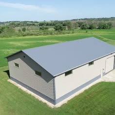 an aerial view of a metal building in the middle of a field