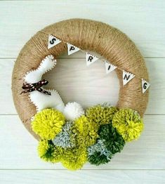 a wreath decorated with pom - poms and bunting