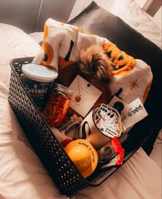 a basket filled with food sitting on top of a bed