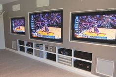 three large televisions mounted on the wall in a room with carpeted flooring