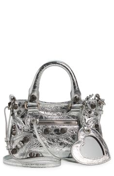 Balenciaga reimagines an '00s style with this spacious tote crafted from richly crinkled metallic leather and detailed with textured hardware. A tasseled zipper pull and heart-shaped mirror bag charm complete the look with signature flair. Top zip closure Top carry handles; removable, adjustable shoulder strap Exterior front zip pocket Structured silhouette with flat base for stability Cotton-canvas lining Leather Made in Italy Designer Handbags Silver Designer Bag, Designer Silver Textured Leather Shoulder Bag, Designer Silver Textured Leather Bag, Mirror Bag, Balenciaga Tote, Designer Handbag Brands, 00s Style, Balenciaga Leather, Shaped Mirror