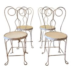 four metal chairs with wooden seats on white background