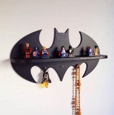 a batman themed shelf with legos on it and beads hanging from the bottom half