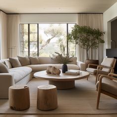 a living room filled with furniture and large windows