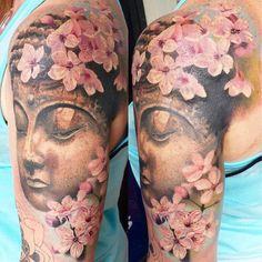 a woman's half sleeve with flowers and buddha face on her left arm in black and grey