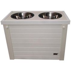 two stainless steel bowls on top of a white cabinet